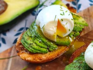 toast croccante con avocado cremoso e uova strapazzate, servito su un piatto rustico, con un tocco di erbe fresche